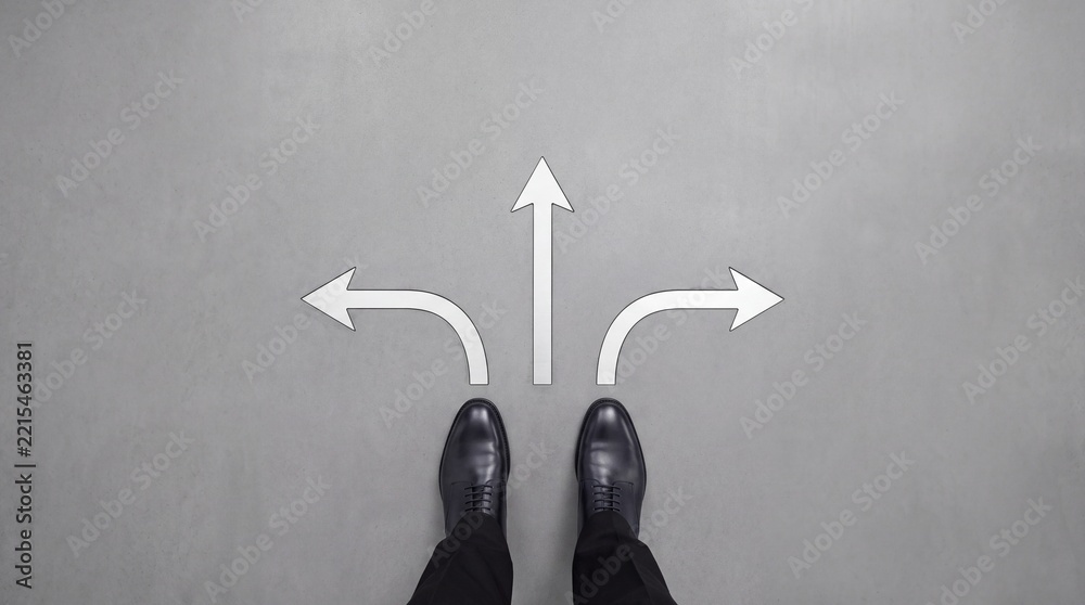 Fototapeta premium Top Down View of Businessman in Formal Black Leather Shoes Standing on Gray Ground with Three Directional Arrows Symbolizing Career Choices, Decision Making, and Future Path Direction Strategy.