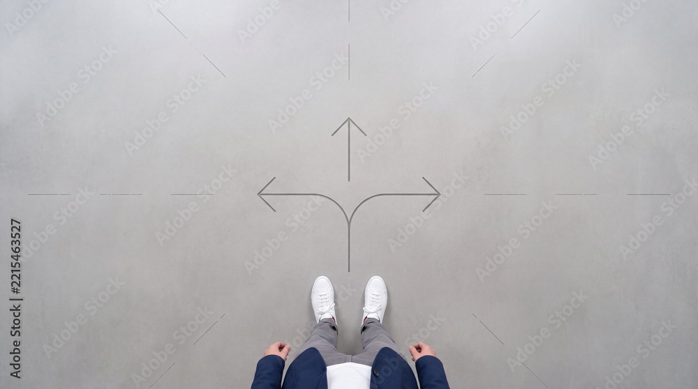 Fototapeta premium Top down overhead view of a businessman standing at a crossroads with three arrows on concrete floor, concept of making a difficult decision, career path choice, and strategic direction.