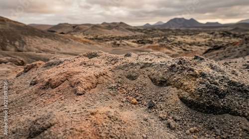 Textured Rocky Terrain of an Arid Volcanic Landscape Under a Cloudy Sky