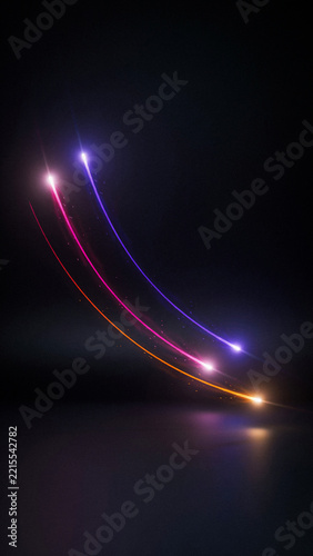 Three glowing colorful light trails curving upwards on a dark surface with abstract multicolor background reflection futuristic creative illumination movement composition perspective