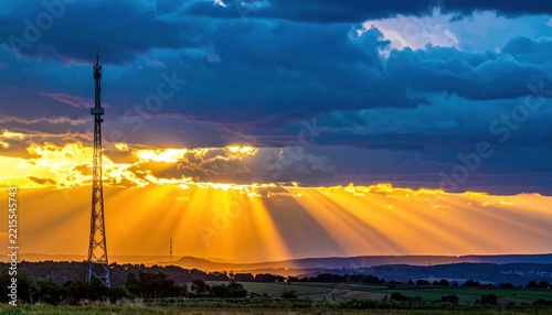 Network tower against vibrant sunset and sunbeam background.
