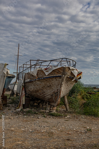 Weathered wooden fishing boat on a  seashore

