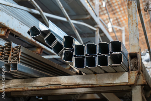 Obraz na plátně Square steel pipes stacked on metal storage racks in warehouse
