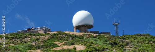 Large radar dome and communication antennas on Pico Arieiro, in Madeira, Portugal, under a clear, deep blue sky