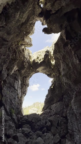 Unique geological rock formations and natural cave window framing the majestic Taurus mountain range