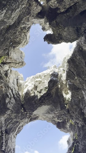 Vertical cinematic view from inside a limestone cave looking out at the Taurus Mountains in Antalya