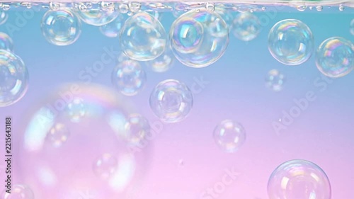 Translucent soap bubbles floating underwater with pastel blue and pink lighting background video footage