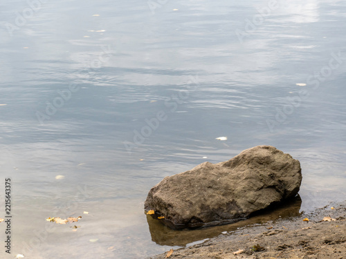 Single large rock rests at water's edge