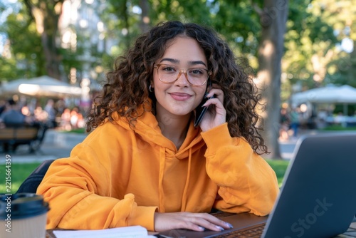 Young woman smiles warmly while talking on phone