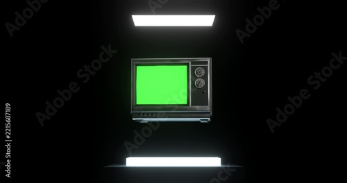 Vintage television with blank green screen floating in mid air illuminated by bright glowing panels in dark background