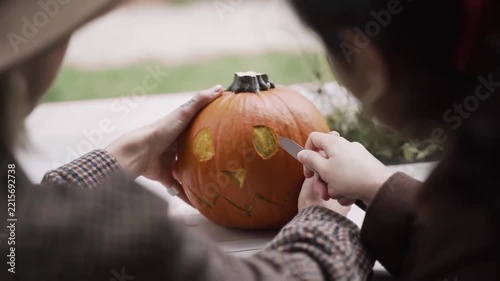 Close Up Hands Carving Halloween Jack-O-Lantern Pumpkin Outdoor