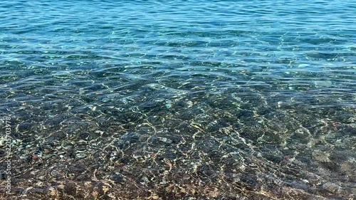Sea clear waves on a pebble beach.