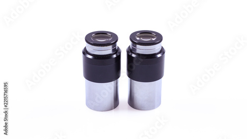 Obraz na plátně Pair of 10x microscope eyepieces with silver metal housings, black knurled rims and visible optical lenses, photographed on a white background