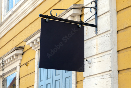 Vintage blank storefront hanging sign mockup on old wooden house