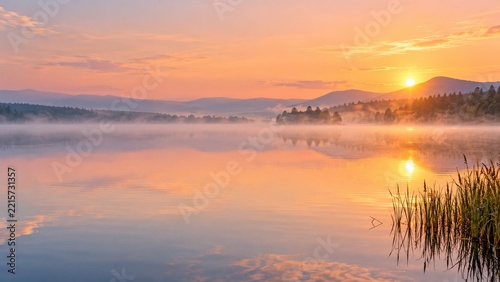 Golden Sunrise over a Misty Mountain Lake with Pine Forest Reflections