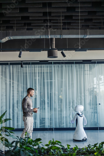 Man interacting with robot in modern office environment