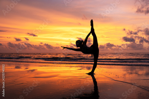Side view silhouette of young gymnast in posing  standing split at the beach during sunset Sabah Borneo
