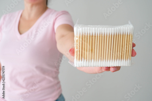 A woman holds a package of cotton swabs