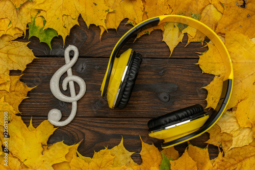 Autumn Music Vibes: Yellow Headphones and Treble Clef Among Fall Leaves