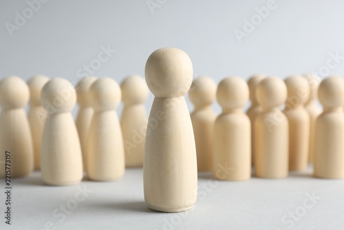 Fotografie Big human figure among smaller ones on light background, closeup