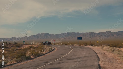 Pickup truck with trailer driving on a desolate desert road