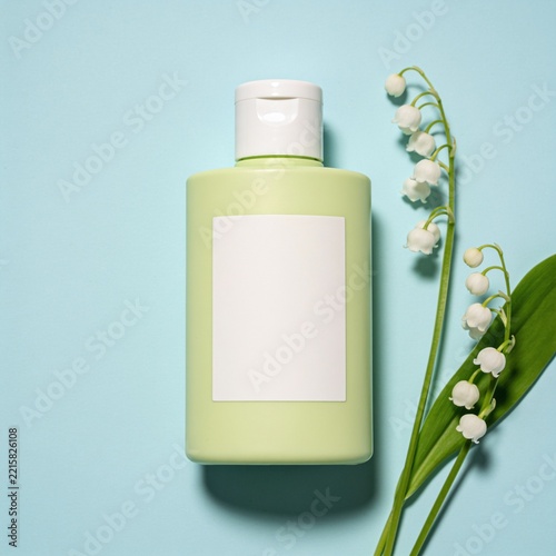Bottle of skincare lotion with lily of the valley flowers skincare cosmetics