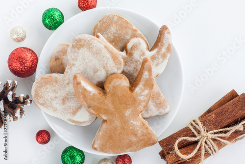 Christmas angel cookie decorated with icing, Christmas baubles, cinnamon sticks and pine cone