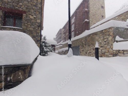 Heavy snowfall burying stone buildings and street lamp in mountain village