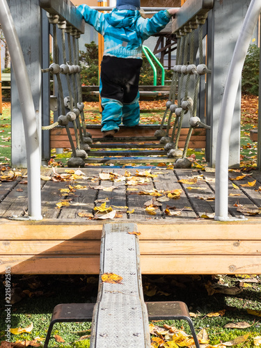 Toddler Navigating Playground Obstacle Course in Autumn
