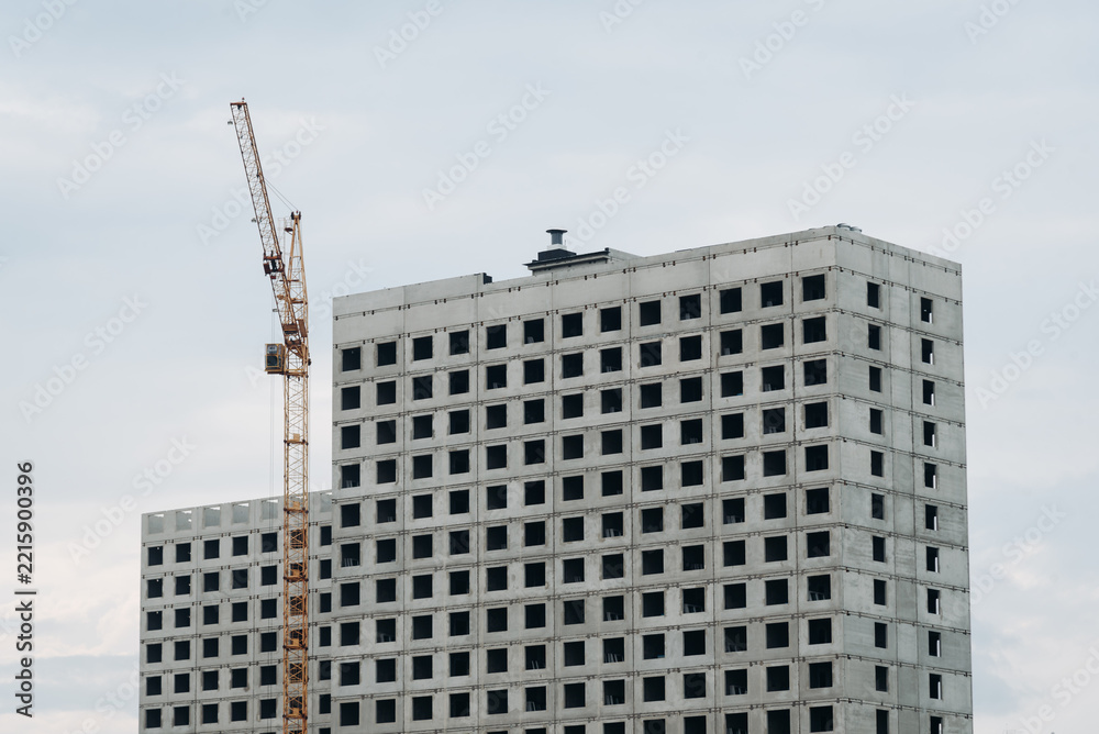 Fototapeta premium multi‑storey panel building under construction and construction crane