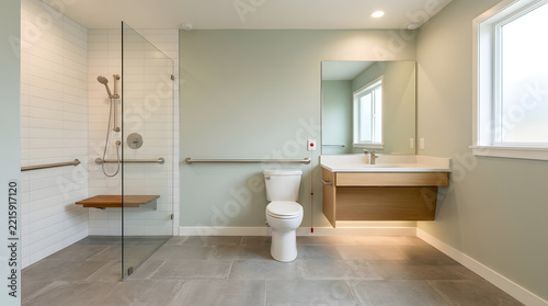 Accessible bathroom interior with grab bars and walk-in shower for
