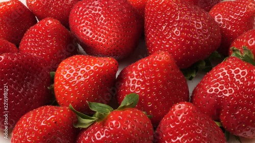 Fresh ripe strawberries rotating on a white background