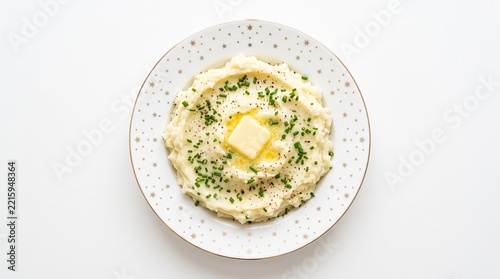 Creamy mashed potatoes with a melting butter pat and fresh chives on a festive star patterned plate