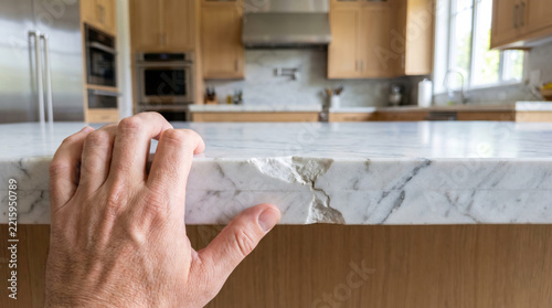 Close up of damaged chip in white marble kitchen countertop