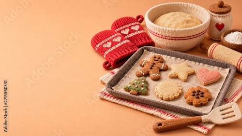 Felt cookies and red knitted oven mitts on a warm peach baking backdrop