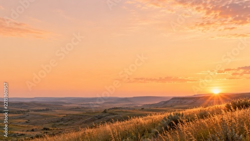 Golden Prairie Hills and Distant Mesas Beneath a Warm Glowing Evening Sky