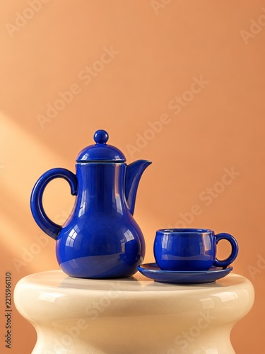 Cobalt Blue Ceramic Coffee Pot and Cup on a Cream Pedestal Against Peach