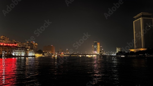 Night view of the Nile river reflecting city lights and illuminated skyscrapers of downtown Cairo