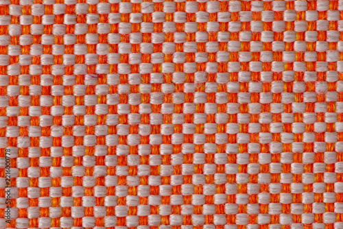 Close up of orange and white woven fabric texture with a classic checkerboard pattern