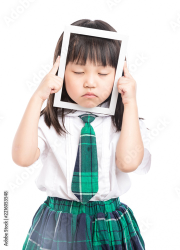 Playful Asian girl in school uniform looking through a white frame making a funny face.