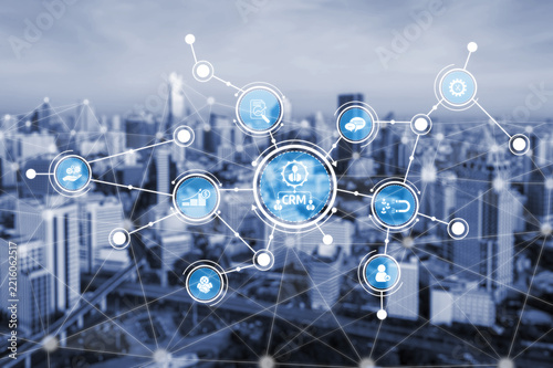 This image portrays a modern business network concept with data connection symbols illustrating customer relationship management, set against an urban city backdrop. Tessel