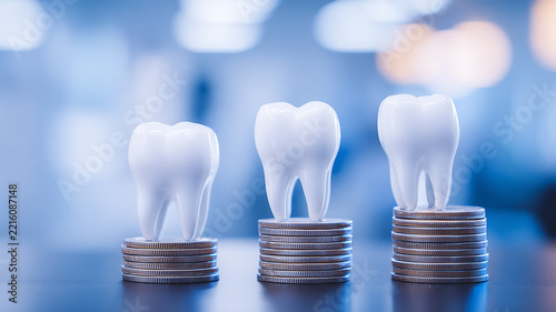 Teeth positioned on stacks of coins represent dental treatment costs healthcare expenses and insurance coverage planning
