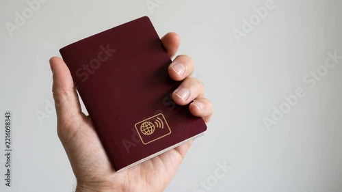 Maroon Passport Held by Hand for Identity Security Confirmation During International Travel Document Verification Contactless Cover Symbol