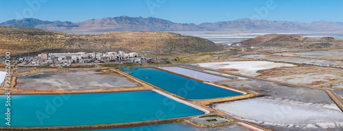 Ogden, United States - 30 September 2026: Aerial view of the Western Zirconium Inc factory and Westinghouse facility, with turquoise wastewater evaporation ponds and arid mountains.