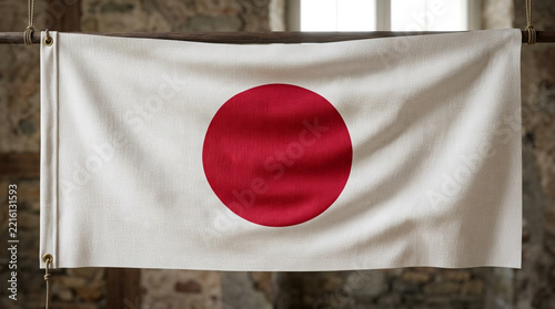 Japanese flag hanging on a wooden pole against a stone wall