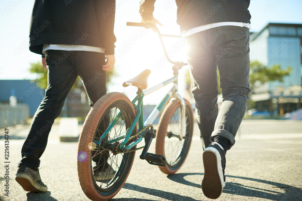Naklejka premium Bicycle, legs and people for outdoor hobby, activity or challenge in urban park. Bike, shoes and feet for cycling, BMX training and skills for competition in city for walking and stunt exercise