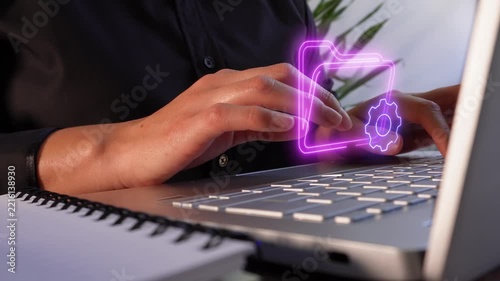 File and process management. Close-up of a professional woman's hands using a computer, showing a virtual icon of a folder and a gear.