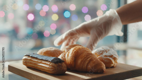 Assorted Pastries with Gloved Hand on Wooden Board