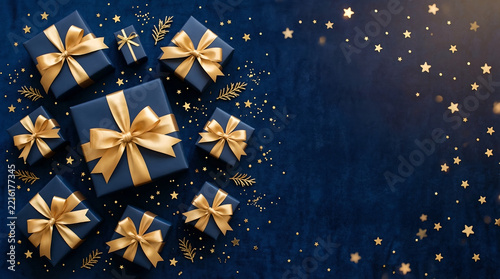 Elegant navy blue gift boxes with gold bows, luxury holiday presents on dark background, festive Christmas celebration banner with golden stars