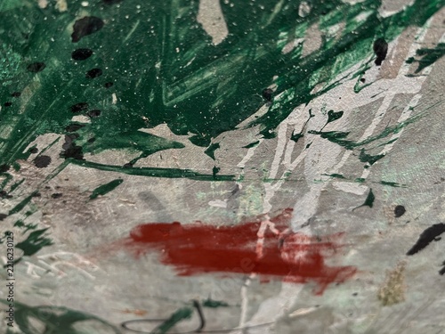 Abstract paint strokes in green, white, and red. Bold brushstrokes swirl across textured canvas surface. Red smear contrasts with vibrant green splatters and white streaks